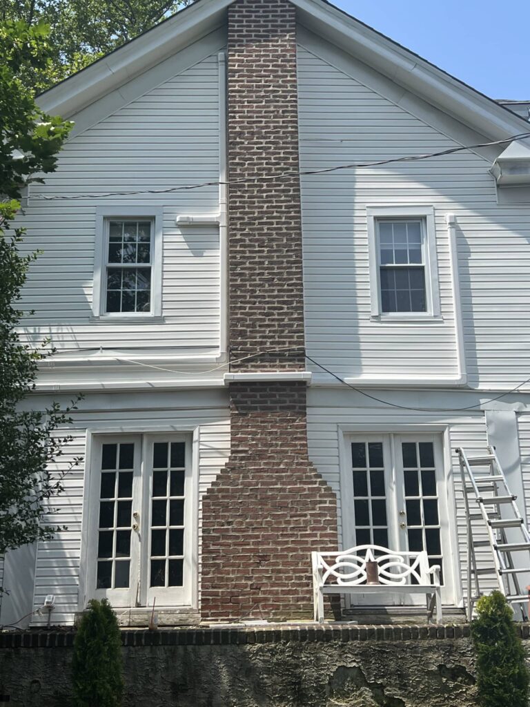 Chimney flanked by french doors, 2 story white house