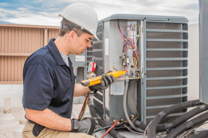 Worker assessing hvac unit Worker assessing hvac unit